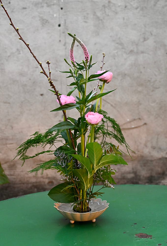 Blomsterarrangemang med fakir bestående av ranunklar.